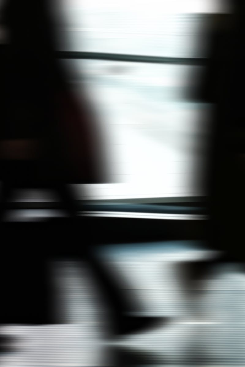Abstract blurred motion of people walking indoors, depicting urban life and busy routines.